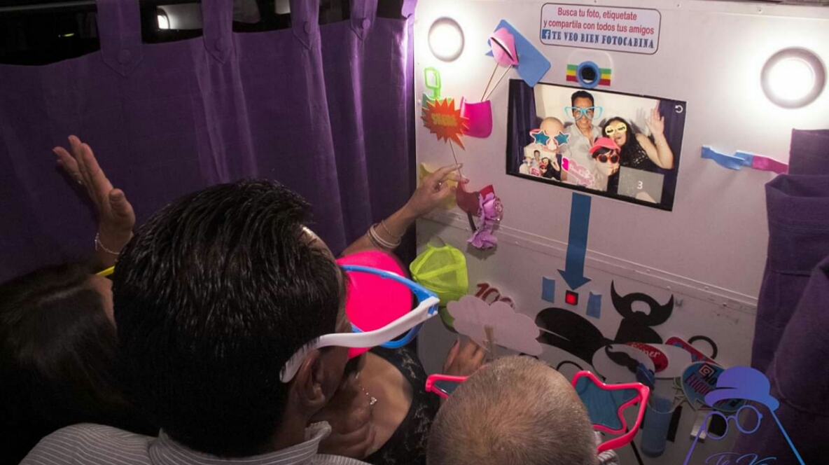Invitados divirtiéndose con props en la fotocabina de Te Veo Bien Fotocabina